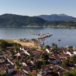 Vista panorâmica da baía de Paraty com ilhas, praias e mar azul cristalino — destino de veleiro na Costa Verde.